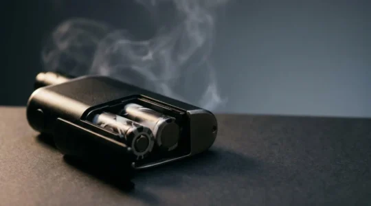 Close-up of dual battery vape mod showing battery compartment and performance indicators