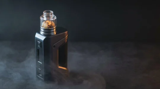 High-performance dual coil RDA vaping device with premium mod in dramatic atmospheric lighting showcasing cloud competition equipment