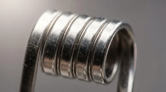Close-up view of stainless steel coil wire showing metallic surface texture and resistance properties for temperature control vaping