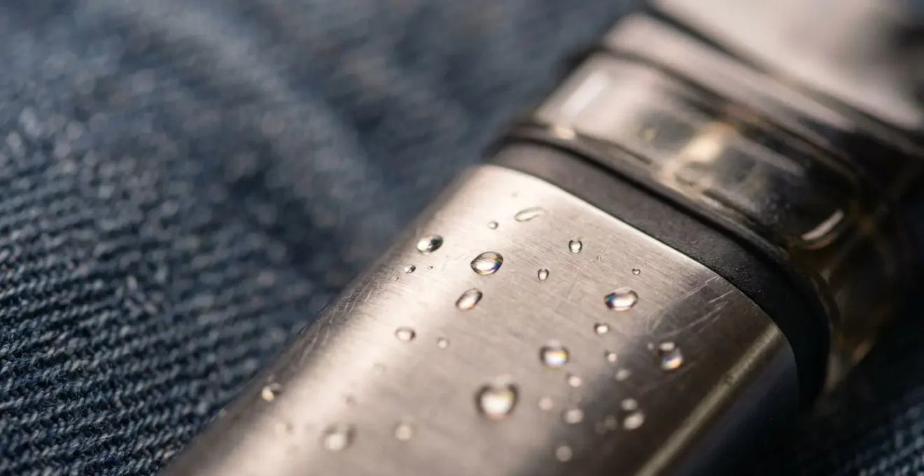 Close-up perspective of a vape device showing condensation and e-liquid residue detail, illustrating common pocket leakage issues